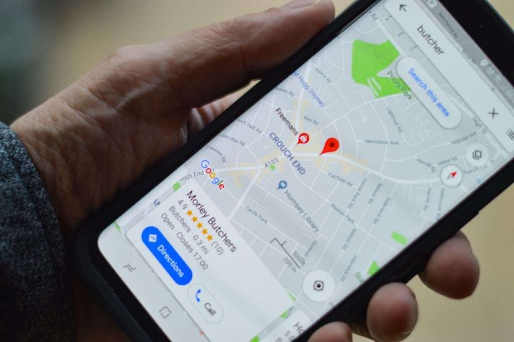 A person holding a cell phone with a google map on it.