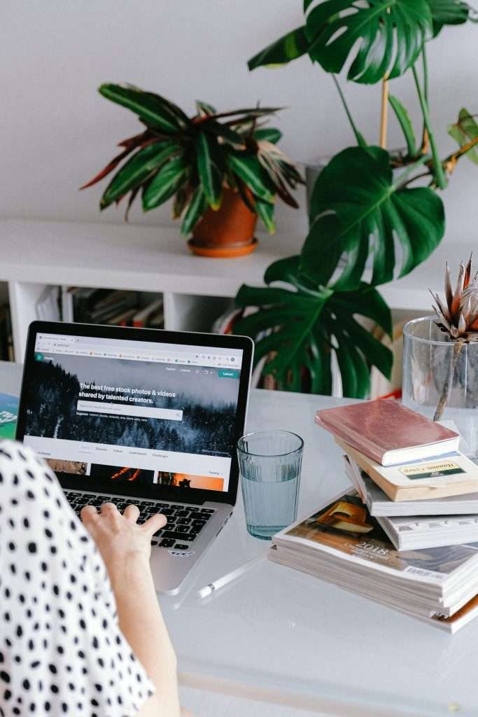 A woman sitting at a desk with a laptop on it.