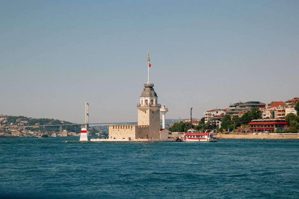 A boat is in the water near a tower.