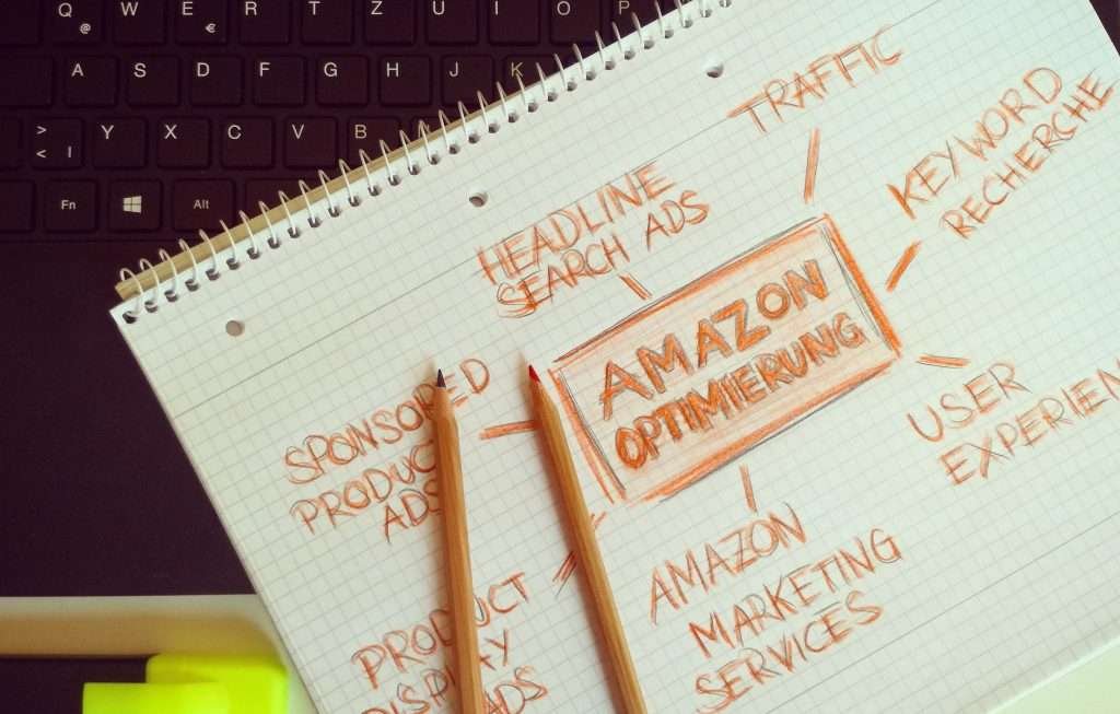 A notepad with the words amazon marketing on it next to a laptop.