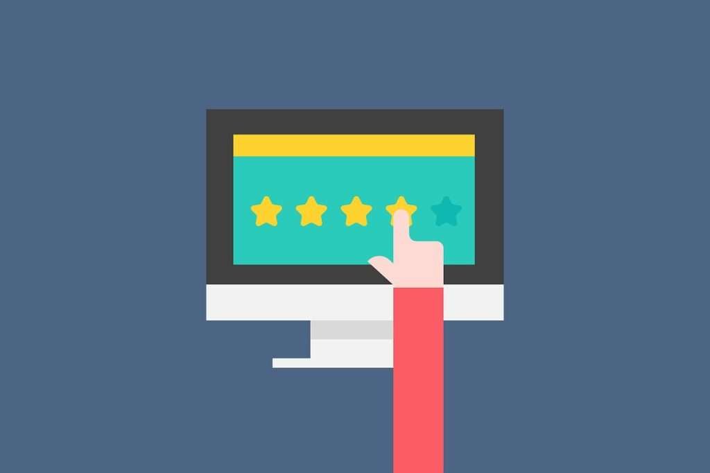 A hand is pointing at a computer screen with five stars on it.