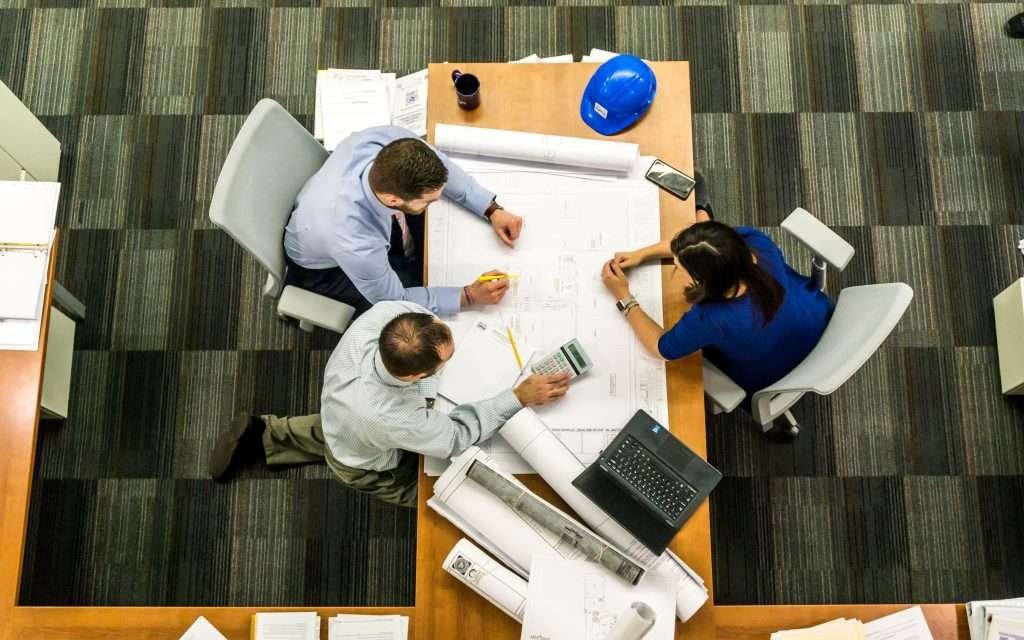 A group of people working at a table in an office.