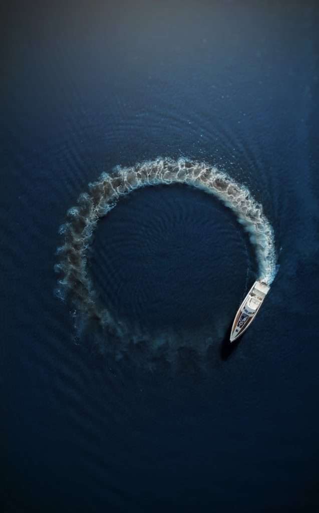 A boat traveling through the water in a circle.